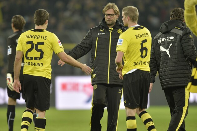 Dortmund head coach Juergen Klopp shakes hands with Sokratis, left, and Sven Bender, right, after the German Bundesliga soccer match between Borussia Dortmund and FC Augsburg in Dortmund,  Germany, Saturday, Jan. 25, 2014. The match ended 2-2.  (AP Photo/Martin Meissner)