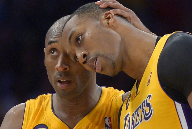 FILE - In this April 5, 2013 file photo, Los Angeles Lakers guard Kobe Bryant, left, hugs center Dwight Howard in the closing seconds of their NBA basketball game against the Memphis Grizzlies in Los Angeles. Howard is being wooed by billboards and by Bryant, while around the NBA teams are beginning to shape their rosters for the next season. (AP Photo/Mark J. Terrill, File)