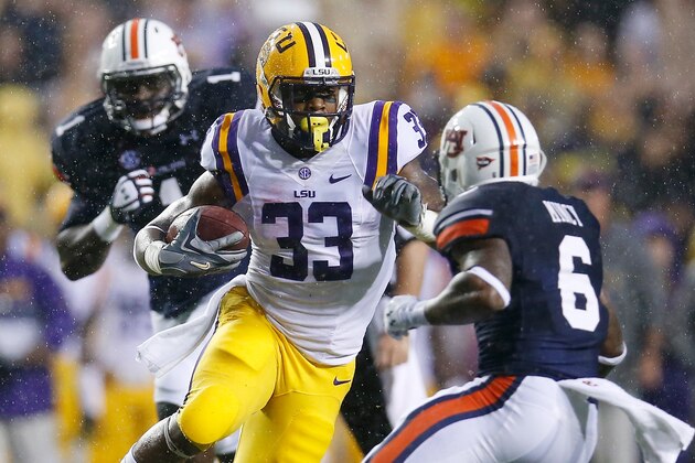 BATON ROUGE, LA - SEPTEMBER 21:  Jeremy Hill #33 of the LSU Tigers runs past Jonathon Mincy #6 of the Auburn Tigers on his way to scoring a touchdown at Tiger Stadium on September 21, 2013 in Baton Rouge, Louisiana.  (Photo by Chris Graythen/Getty Images)