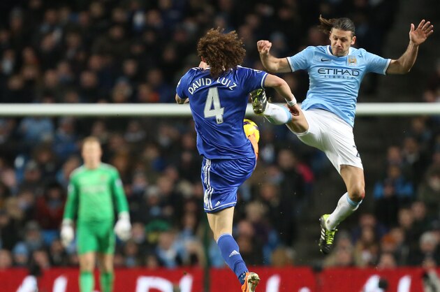 Manchester City's Martin Demichelis, right jumps to challenge Chelsea's David Luiz for the ball during their English Premier League soccer match at the Etihad Stadium, Manchester, England, Monday Feb. 3, 2014. (AP Photo/Jon Super)