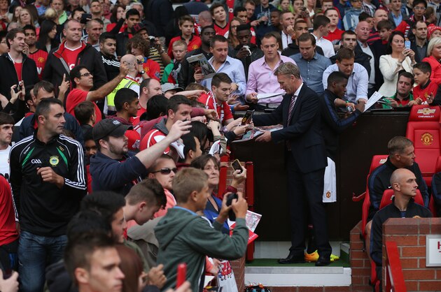 MANCHESTER, ENGLAND - AUGUST 09:  Manchester United manager David Moyes signs autographs for the fans before the Rio Ferdinand Testimonial Match between Manchester United and Sevilla at Old Trafford on August 9, 2013 in Manchester, England.  (Photo by Clive Brunskill/Getty Images)