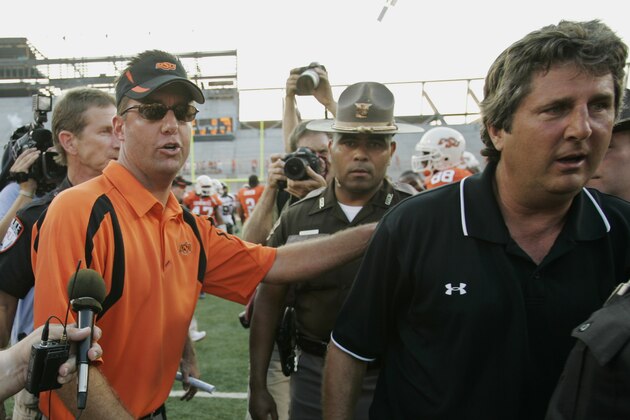 Oklahoma State head coach Mike Gundy, left, pats Texas Tech head Mike Leach, right, on the back, following a college football game in Stillwater, Okla, Saturday, Sept. 22, 2007. Oklahoma State won the game 49-45. (AP Photo/Sue Ogrocki)
