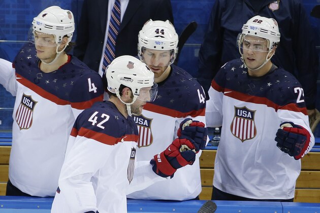 USA forward David Backes celerates his goal against Slovakia with his teammates on the bench during the 2014 Winter Olympics men's ice hockey game at Shayba Arena, Thursday, Feb. 13, 2014, in Sochi, Russia. (AP Photo/Matt Slocum)