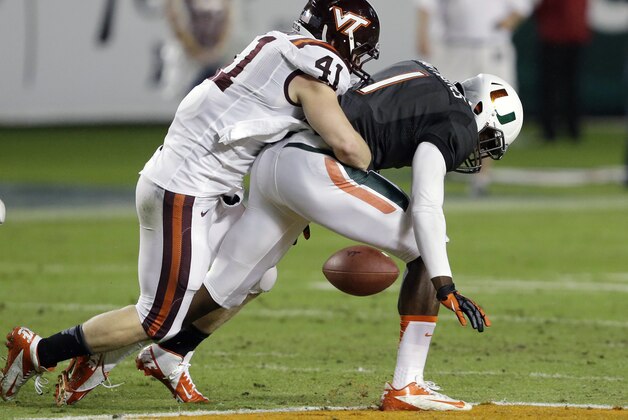Miami wide receiver Artie Burns (1) fumbles the ball as he is tackled by Virginia Tech's Derek DiNardo (41) during the first half of an NCAA college football game, Saturday, Nov. 9, 2013, in Miami Gardens, Fla. (AP Photo/Wilfredo Lee)
