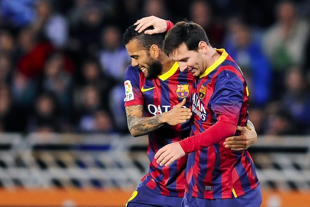 FC Barcelona's Lionel Messi of Argentina, right, celebrates his goal with Barcelona's Daniel Alves of Brazil,  during their Spanish Copa del Rey semifinal second leg soccer match between Real Sociedad and FC Barcelona , at Anoeta  stadium, in San Sebastian northern Spain, Wednesday, Feb. 12, 2014. (AP Photo/Alvaro Barrientos)