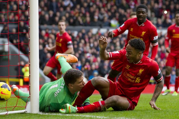 Liverpool's Raheem Sterling, bottom right, collides with Arsenal's goalkeeper Wojciech Szczesny as he narrowly fails to score a third goal during their English Premier League soccer match at Anfield Stadium, Liverpool, England, Saturday Feb. 8, 2014. (AP Photo/Jon Super)