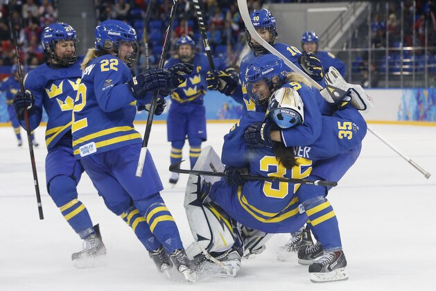 Team Sweden celebrates this 4-2 victory over Finland during the 2014 Winter Olympics women's ice hockey quarterfinal game at Shayba Arena, Saturday, Feb. 15, 2014, in Sochi, Russia. (AP Photo/Petr David Josek)