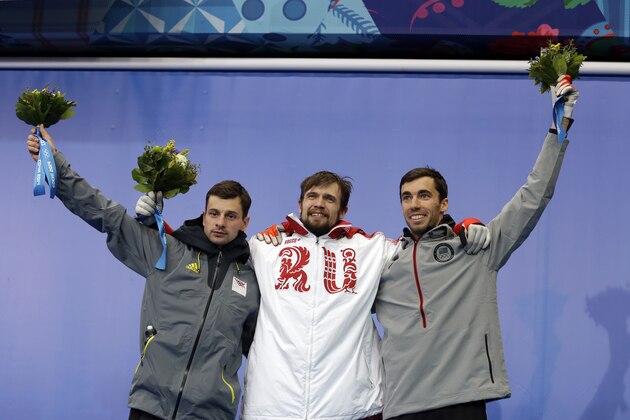 From left to right silver medalist Martins Dukurs of Latvia, gold medalist Alexander Tretiakov of Russia and bronze medalist Matthew Antoine of the United States pose during the flower ceremony after the men's skeleton competition at the 2014 Winter Olympics, Saturday, Feb. 15, 2014, in Krasnaya Polyana, Russia. (AP Photo/Natacha Pisarenko)