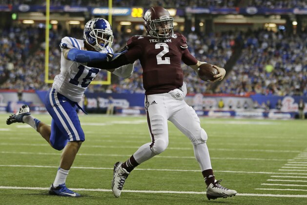 Texas A&M quarterback Johnny Manziel (2) scores a touchdown as Duke safety Jeremy Cash (16) defends in the second half of the Chick-fil-A Bowl NCAA college football game Tuesday, Dec. 31, 2013, in Atlanta. (AP Photo/John Bazemore)