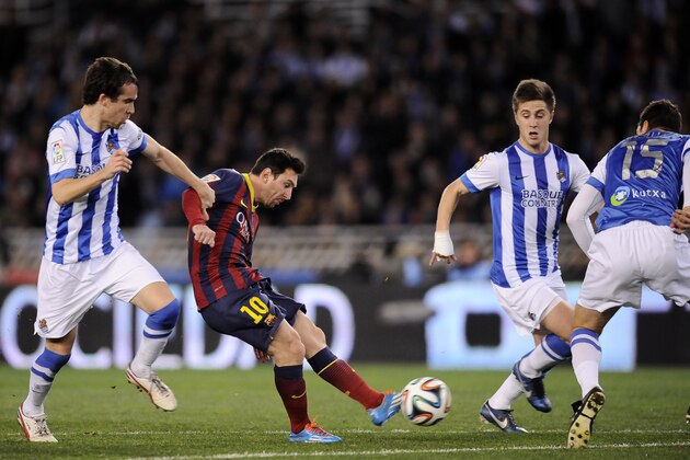 FC Barcelona's Lionel Messi of Argentina, center, shoots the ball to the goal between Real Sociedad's Jon Gaztanaga, right, and Mikel Gonzalez, left, during their Spanish Copa del Rey semifinal second leg soccer match, at Anoeta stadium, in San Sebastian northern Spain, Wednesday, Feb. 12, 2014. (AP Photo/Alvaro Barrientos)