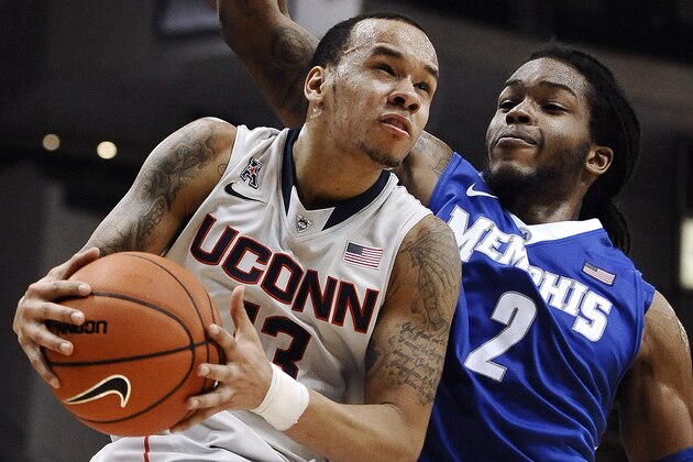 Connecticut's Shabazz Napier, left, drives to the basket as Memphis' Shaq Goodwin defends during the second half an NCAA college basketball game, Saturday, Feb. 15, 2014, in Hartford, Conn. Connecticut won 86-81 in overtime. (AP Photo/Jessica Hill)