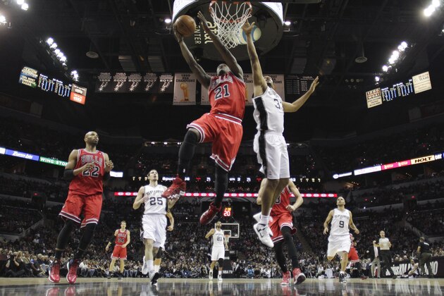 Chicago Bulls' Jimmy Butler (21) scores past San Antonio Spurs defender Boris Diaw  (33) during the first half of an NBA basketball game, Wednesday, Jan. 29, 2014, in San Antonio.  (AP Photo/Eric Gay)
