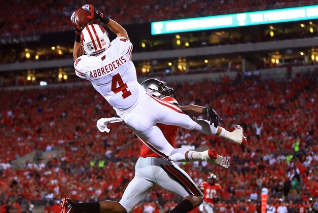 Sep 28, 2013; Columbus, OH, USA; Wisconsin Badgers wide receiver Jared Abbrederis (4) makes a jumping catch while being defended by a Ohio State Buckeyes defender during the first quarter at Ohio Stadium. Mandatory Credit: Andrew Weber-USA TODAY Sports