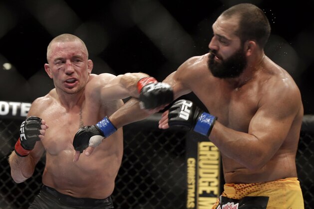 Johny Hendricks, right, exchanges punches with Georges St. Pierre, of Canada, during a UFC 167 mixed martial arts championship welterweight bout on Saturday, Nov. 16, 2013, in Las Vegas. St. Pierre won by split decision. (AP Photo/Isaac Brekken)