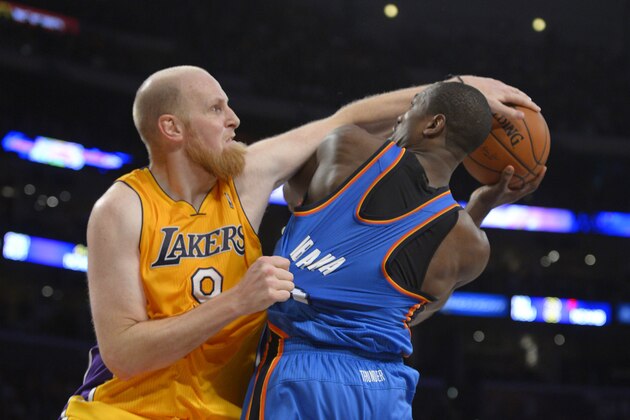 Los Angeles Lakers center Chris Kaman, left, fouls Oklahoma City Thunder power forward Serge Ibaka, of Congo, during the second half of an NBA basketball game, Thursday, Feb. 13, 2014, in Los Angeles. (AP Photo/Mark J. Terrill)