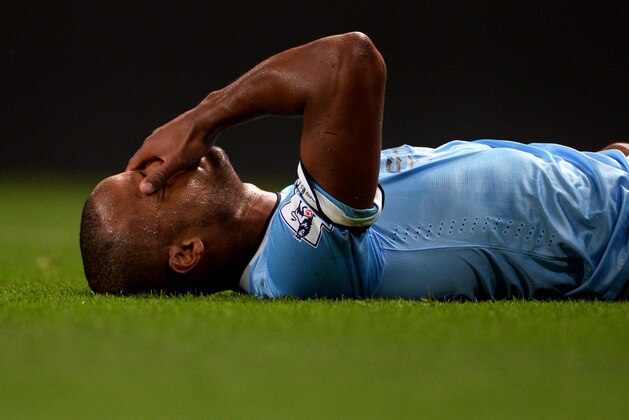 MANCHESTER, ENGLAND - AUGUST 19:  Vincent Kompany of Manchester City lies injured on the pitch after making a challenge on Sammy Ameobi of Newcastle United during the Barclays Premier League match between Manchester City and Newcastle United at the Etihad Stadium on August 19, 2013 in Manchester, England.  (Photo by Michael Regan/Getty Images)