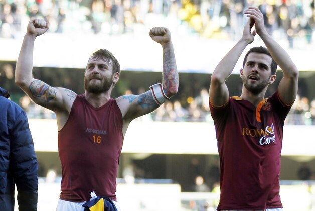 AS Roma's Miralem Pjanic, right, of Bosnia, and teammate Daniele De Rossi wave to supporters at the end of a Serie A soccer match at Bentegodi stadium in Verona, Italy, Sunday, Jan. 26, 2014. AS Roma won 3-1. (AP Photo/Felice Calabro')