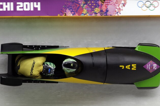 The team from Jamaica JAM-1, piloted by Winston Watts and brakeman Marvin Dixon, take a turn during the men's two-man bobsled competition at the 2014 Winter Olympics, Sunday, Feb. 16, 2014, in Krasnaya Polyana, Russia. (AP Photo/Michael Sohn)