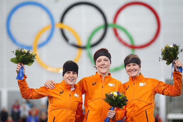 Athletes from the Netherlands, from left to right, silver medallist Ireen Wust, Gold medallist Jorien ter Mors and bronze medallist Lotte van Beek celebrate during the flower ceremony for the women's 1,500-meter speedskating race at the Adler Arena Skating Center during the 2014 Winter Olympics in Sochi, Russia, Sunday, Feb. 16, 2014. (AP Photo/Pavel Golovkin)