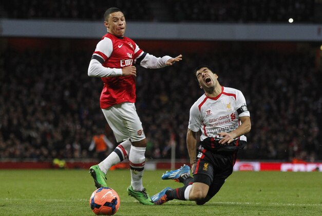 Liverpool's Luis Suarez, right, is tackled by Arsenal's Alex Oxlade-Chamberlain during their English FA Cup fifth round soccer match at Emirates Stadium in London, Sunday, Feb. 16, 2014. (AP Photo/Sang Tan)