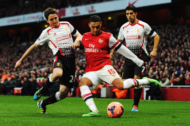 LONDON, ENGLAND - FEBRUARY 16:  Alex Oxlade-Chamberlain (R) of Arsenal tries to get his cross in ahead of Joe Allen (L) of Liverpool during the FA Cup Fifth Round match between Arsenal and Liverpool at the Emirates Stadium on February 16, 2014 in London, England.  (Photo by Shaun Botterill/Getty Images)