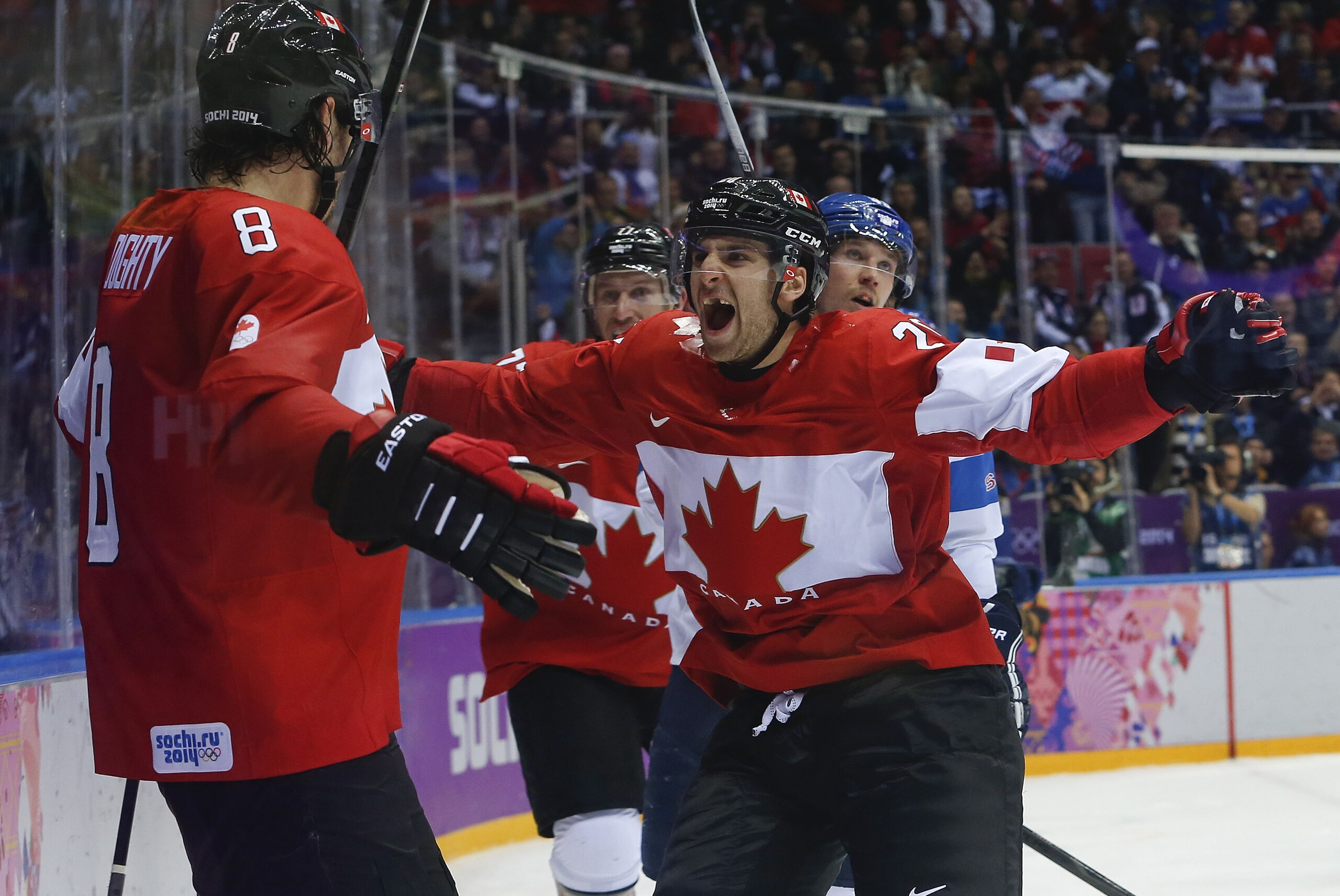 Canada forward John Tavares, right, and forward Jeff Carter, second from left, celebrate with defenseman Drew Doughty (8) after Doughty scored a sudden death overtime goal against Finland during a men's ice hockey game at the 2014 Winter Olympics, Sunday, Feb. 16, 2014, in Sochi, Russia. Canada won 2-1. (AP Photo/Mark Humphrey)