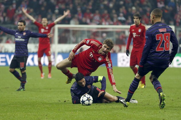Bayern's Thomas Mueller, top, and Arsenal's Mikel Arteta challenge for the ball during the Champions League round of 16 second leg soccer match between FC Bayern Munich and FC Arsenal in Munich, Germany, Wednesday, March 13, 2013. (AP Photo/Matthias Schrader)
