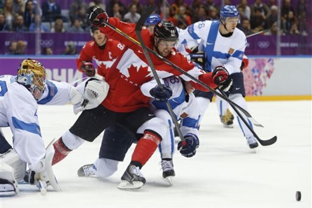 Canada forward Benn Jamie (22) scrambles against Finland defenseman Juuso Hietanen in the first  period of a men's ice hockey game at the 2014 Winter Olympics, Sunday, Feb. 16, 2014, in Sochi, Russia. (AP Photo/Mark Humphrey)