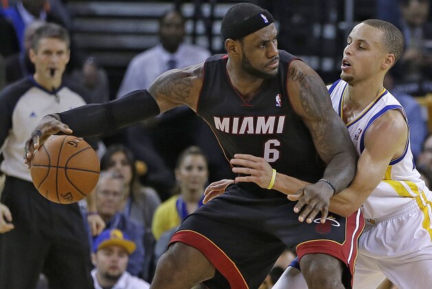 Miami Heat's LeBron James, left, drives the ball against Golden State Warriors' Stephen Curry during the second half of an NBA basketball game Wednesday, Feb. 12, 2014, in Oakland, Calif. (AP Photo/Ben Margot)