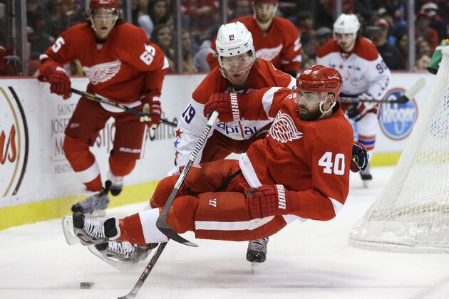 Detroit Red Wings left wing Henrik Zetterberg (40) of Sweden is tripped by Washington Capitals center Nicklas Backstrom (19), of Sweden, during the first period of an NHL hockey game in Detroit, Friday, Jan. 31, 2014. (AP Photo/Carlos Osorio)