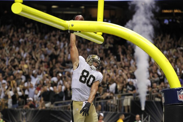 New Orleans Saints tight end Jimmy Graham (80) slam dunks over the goalpost after scoring on a touchdown reception in the second half of an NFL football game against the Arizona Cardinals in New Orleans, Sunday, Sept. 22, 2013. (AP Photo/Bill Haber)