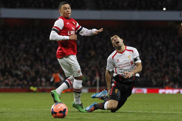 Liverpool's Luis Suarez, right, is tackled by Arsenal's Alex Oxlade-Chamberlain during their English FA Cup fifth round soccer match at Emirates Stadium in London, Sunday, Feb. 16, 2014. (AP Photo/Sang Tan)