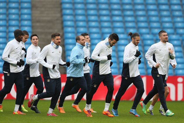 MANCHESTER, ENGLAND - FEBRUARY 17:  Aleksandar Kolarov and James Milner of Manchester City lead the pack during a training session ahead of their UEFA Champions League Round of 16 match 1st leg against Barcelona  at Etihad Stadium on February 17, 2014 in Manchester, England.  (Photo by Clive Brunskill/Getty Images)