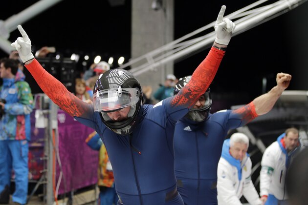 The team from Russia RUS-1, piloted by Alexander Zubkov and brakeman Alexey Voevoda, celebrate their gold medal run during the men's two-man bobsled competition at the 2014 Winter Olympics, Monday, Feb. 17, 2014, in Krasnaya Polyana, Russia. (AP Photo/Jae C. Hong)