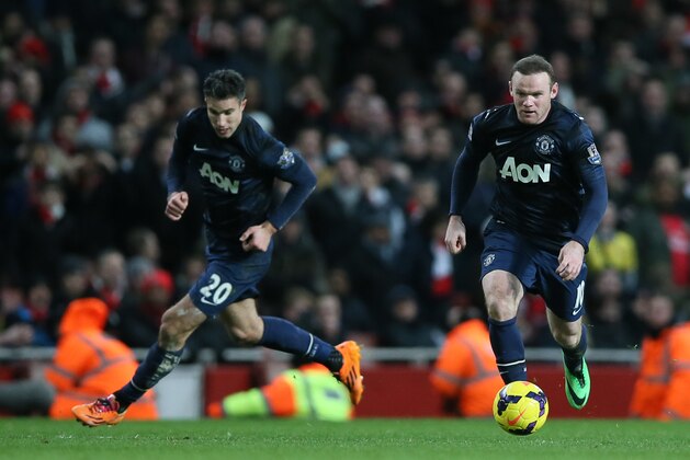 Manchester United's Wayne Rooney, right, takes the ball forward with teammate Robin Van Persie during their English Premier League soccer match between Arsenal and Manchester United at the Emirates stadium in London, Wednesday, Feb. 12, 2014. (AP Photo/Alastair Grant)