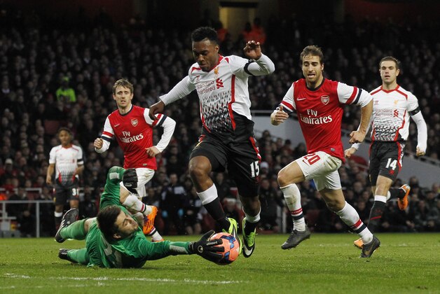 Arsenal's goalkeeper Lukasz Fabianski, left lower, stop Liverpool's Daniel Sturridge, center, getting through during their English FA Cup fifth round soccer match at Emirates Stadium in London, Sunday, Feb. 16, 2014. (AP Photo/Sang Tan)
