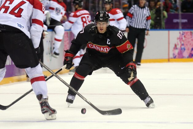 Feb 14, 2014; Sochi, RUSSIA; Canada forward Sidney Crosby (87) defends against Austria defenseman Andre Lakos (64) in a men's preliminary round ice hockey game during the Sochi 2014 Olympic Winter Games at Bolshoy Ice Dome. Mandatory Credit: Winslow Townson-USA TODAY Sports