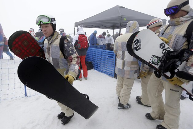 United States' Nate Holland, left, carres his  snowboards after the fog caused cancellation of the men's snowboard cross competition at the Rosa Khutor Extreme Park, at the 2014 Winter Olympics, Monday, Feb. 17, 2014, in Krasnaya Polyana, Russia. (AP Photo/Luca Bruno)