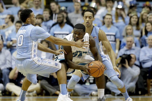 North Carolina's Nate Britt (0) and J.P. Tokoto guard UNC Wilmington's Addison Spruill during the first half of an NCAA college basketball game in Chapel Hill, N.C., Tuesday, Dec. 31, 2013. (AP Photo/Gerry Broome)