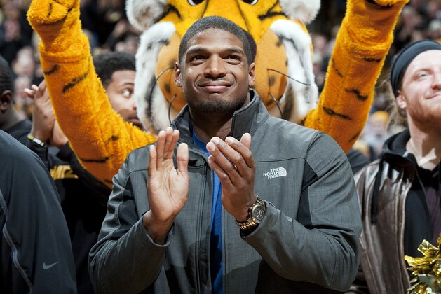 Missouri's All-American defensive end Michael Sam claps during the Cotton Bowl trophy presentation at halftime of an NCAA college basketball game between Missouri and Tennessee, Saturday, Feb. 15, 2014, in Columbia, Mo. Sam came out to the entire country Sunday, Feb. 9, and could become the first openly gay player in the NFL. (AP Photo/L.G. Patterson)