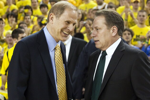 Michigan head coach John Beilein, left, speaks with Michigan State head coach Tom Izzo in the first half of an NCAA college basketball game, Tuesday, Jan. 26, 2010, in Ann Arbor, Mich. (AP Photo/Tony Ding)