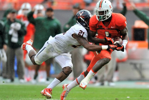 Nov 23, 2013; Miami Gardens, FL, USA;  Miami Hurricanes wide receiver Allen Hurns (1) makes a catch as Virginia Cavaliers safety Brandon Phelps (21) makes the tackle during the third quarter at Sun Life Stadium. Mandatory Credit: Steve Mitchell-USA TODAY Sports