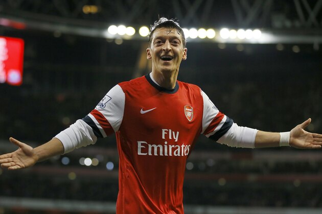 Arsenal's Mesut Ozil celebrates after scoring the opening goal during the English Premier League soccer match between Arsenal and Everton at the Emirates Stadium in London, Sunday, Dec. 8, 2013. (AP Photo/Kirsty Wigglesworth)