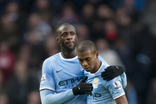 Manchester City's Fernandinho, right, is congratulated by teammate Yaya Toure after his second goal against Arsenal during their English Premier League soccer match at the Etihad Stadium, Manchester, England, Saturday Dec. 14, 2013. (AP Photo/Jon Super)