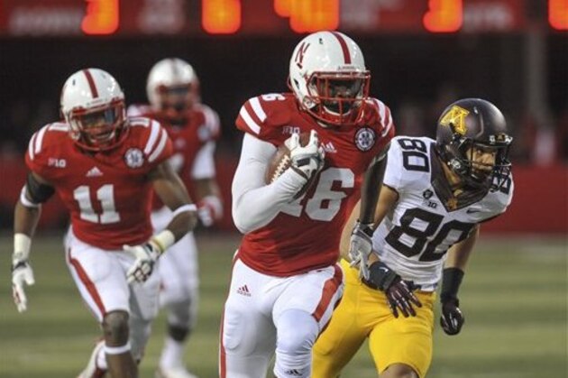 Nebraska's Stanley Jean-Baptiste (16) runs for a touchdown after intercepting a pass from Minnesota quarterback Philip Nelson which bounced off of  Minnesota's Devin Crawford-Tufts (80), in the second half of an NCAA college football game in Lincoln, Neb., Saturday, Nov. 17, 2012. Nebraska won 38-14. At left is Nebraska's Andrew Green. (AP Photo/Dave Weaver)