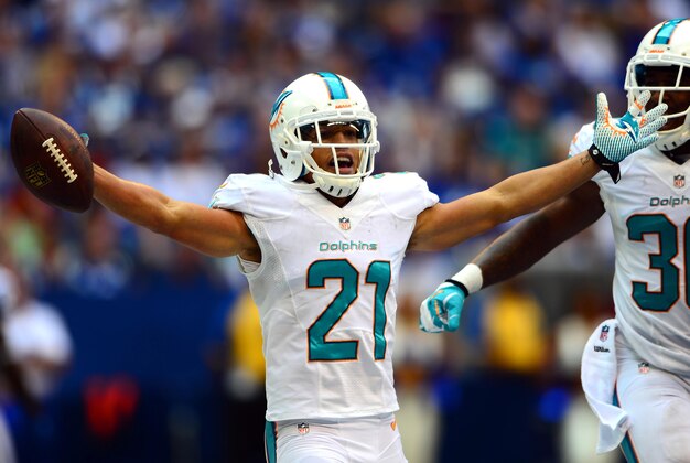 Sep 15, 2013; Indianapolis, IN, USA; Miami Dolphins cornerback Brent Grimes (21) celebrates with teammate after intercepting a pass during the third quarter against the Indianapolis Colts at Lucas Oil Stadium. Mandatory Credit: Andrew Weber-USA TODAY Sports