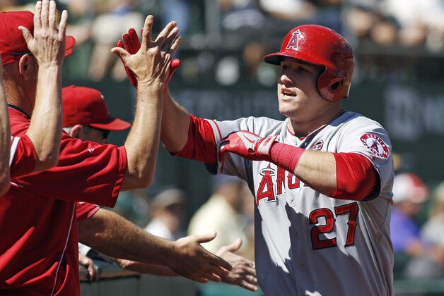 Los Angeles Angels' Mike Trout is greeted in the dugout after hitting a two-run homer against the Oakland Athletics during the first inning of a baseball game, Wednesday, Sept. 18, 2013, in Oakland, Calif. (AP Photo/George Nikitin)