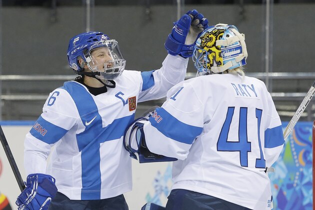 Jenni Hiirikoski of Finland celebrates their 2-1 win over Germany with goalkeeper Noora Raty after the 2014 Winter Olympics women's ice hockey game at Shayba Arena, Sunday, Feb. 16, 2014, in Sochi, Russia. (AP Photo/Matt Slocum)