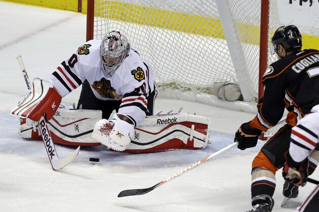 Chicago Blackhawks goalie Corey Crawford (50) defends the goal as Anaheim Ducks center Andrew Cogliano (7) attacks in the first period of an NHL hockey game in Anaheim, Calif., Wednesday, Feb. 5, 2014. The Blackhawks won, 2-0. (AP Photo/Reed Saxon)