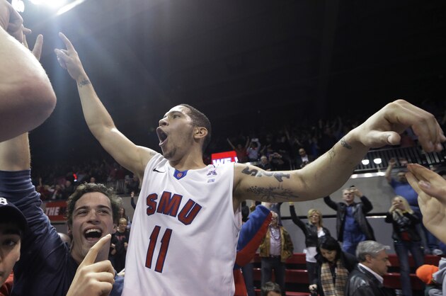 SMU guard Nic Moore celebrates with fans on the court after an NCAA college basketball game against Cincinnati on Saturday, Feb. 8, 2014, in Dallas. SMU won 76-55. (AP Photo/LM Otero)